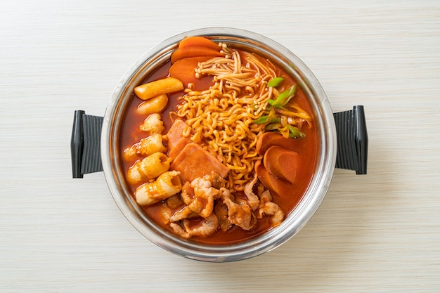 Budae jjigae ou budaejjigae (guisado do exército ou guisado da base do exército). é carregado com kimchi, spam, linguiças, macarrão ramen