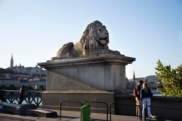 BUDAPESTE HUNGRIA 22 DE SETEMBRO Estátua de leão de arte Húngaros para viajantes pessoas visitam e tiram fotos na Ponte das Correntes de Budapeste para atravessar o rio Danúbio em 22 de setembro de 2019 em Budapeste Hungria