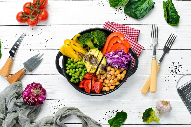 Buddha Bowl Kichererbsen Avocados Brokkoli Paprika Grüne Erbsen Tomaten Gemüsesalat Draufsicht Freier Platz für Ihren Text