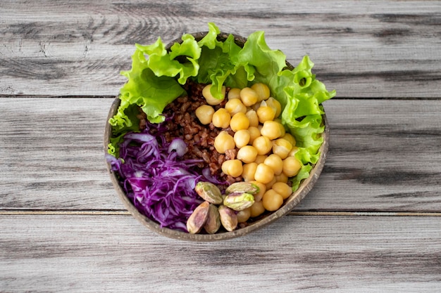 Buddha bowl vegano con verduras garbanzos arroz rojo pistachos Una comida sana y equilibrada en un bowl de coco