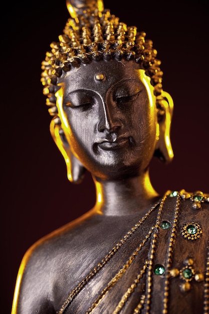 Buddha-Statue mit Schein vor schwarzem Hintergrund