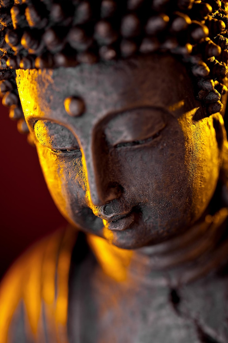 Foto buddha-statuenkopfnahaufnahme mit glühen gegen schwarzen hintergrund