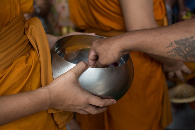 Buddhistische Mönche erhalten zum Ende der buddhistischen Fastenzeit ein Essensangebot von Menschen