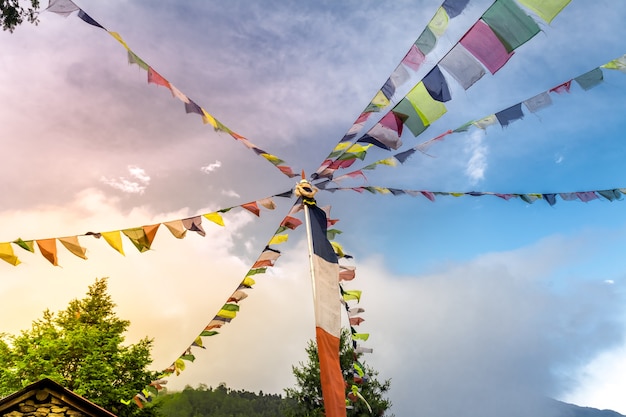 Buddhistische tibetische Gebetsfahnen gegen blauen Himmel mit einer Wolke viele bunte wehende Fahnen ausgesetzt