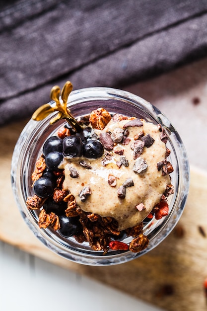 Budín de chía con bayas, granola y mantequilla de maní en frasco, vista superior