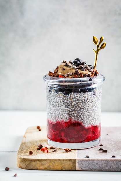 Budín de chía con bayas, granola y mantequilla de maní en frasco