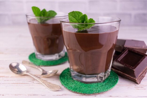 Budín de chocolate o mousse en vasos servidos con hojas de menta