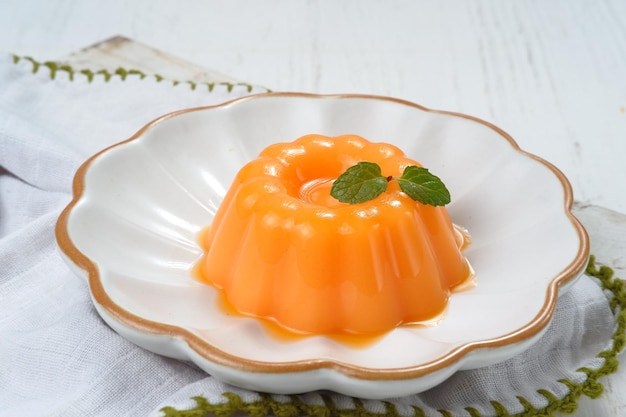 Budín de mango, gelatina, postre en placa blanca.sobre fondo blanco.