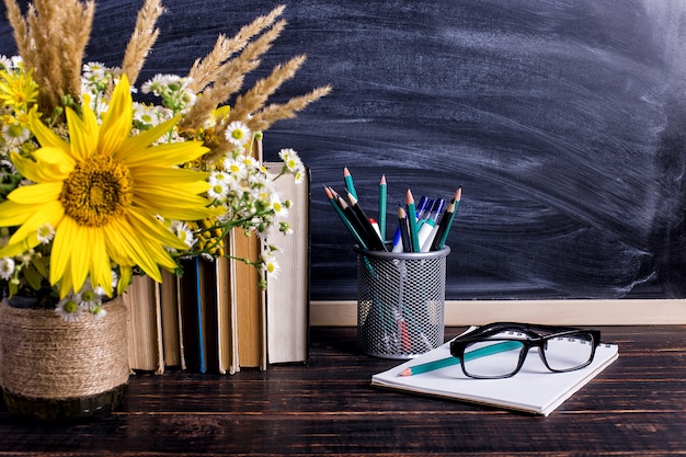 Bücher, Gläser, Markierungen und ein Blumenstrauß in einer Vase auf Weiß