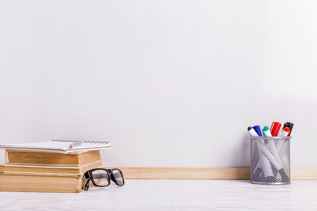 Bücher, Markierungen, Notizbuch, Bleistift und Gläser auf dem Tisch