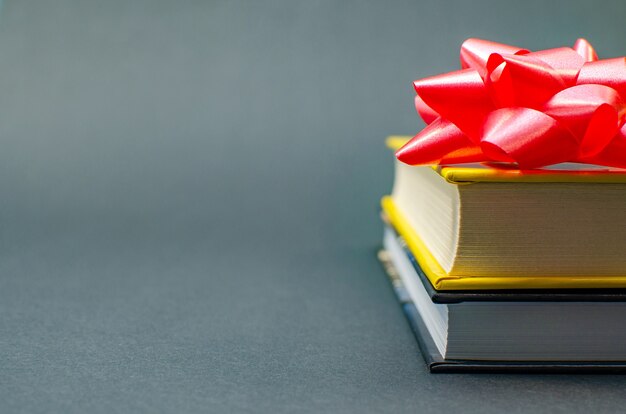 Foto bücher mit farbigem klebeband auf dem tisch vor dunklem hintergrund umwickelt. platz kopieren.