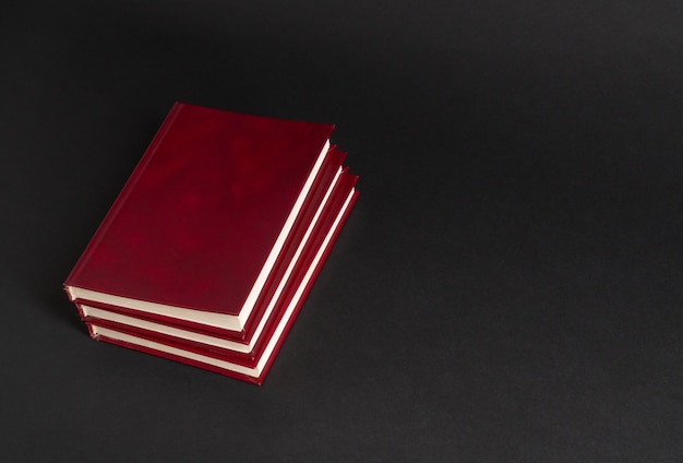 Bücher mit rotem Einband auf schwarzem Hintergrund, isoliert. zurück zur Schule