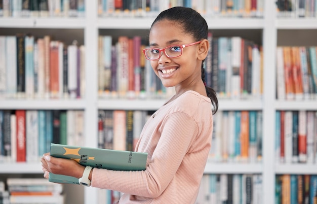 Bücherbildung oder Mädchenlesung in der Bibliothek für Wissen oder Entwicklung für zukünftiges Wachstum Stipendienporträt oder Schülerin mit einem fröhlichen Lächeln beim Studieren oder Lernen von Informationen in einer lustigen Geschichte