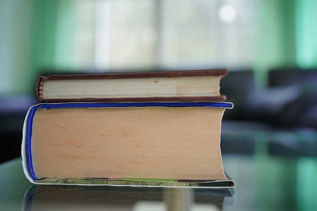 Foto bücherstapel auf glastisch mit blur-sofa-set im wohnzimmer