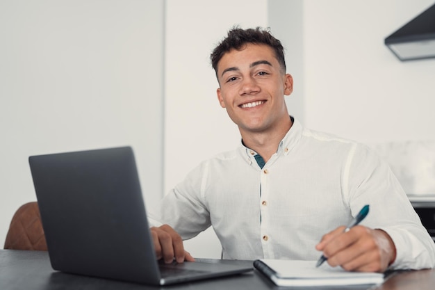 Buen aspecto empleado de oficina del milenio con gafas sentado en el escritorio
