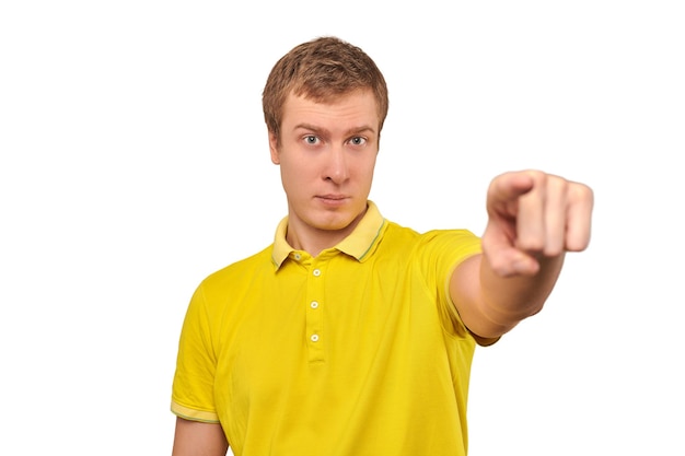 Buen chico guapo en camiseta Polo amarilla casual apuntando hacia adelante aislado sobre fondo blanco.