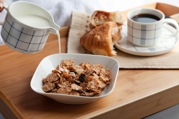 Buen comienzo del día para tener la comida adecuada desayuno saludable en la cama con copos de maíz y frutas secas