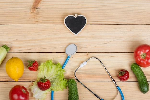 Buen concepto de dieta y salud pizarra en forma de estetoscopio cardíaco y verduras