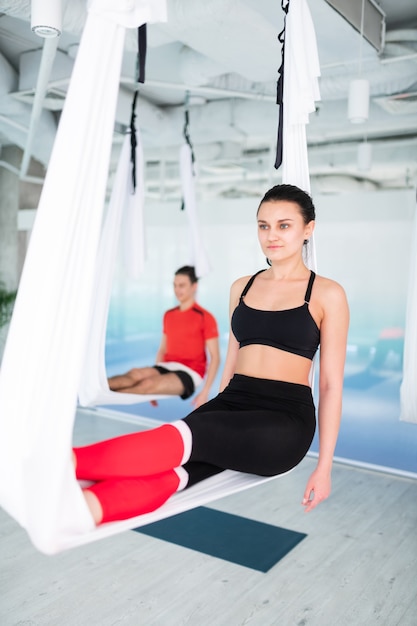 Buen cuerpo. Mujer de cabello oscuro con un cuerpo agradable que se siente increíble mientras practica yoga volador