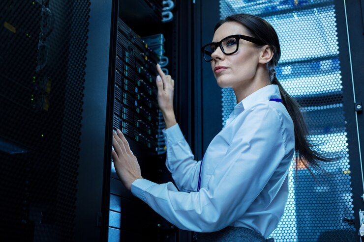 Foto buen dia de trabajo. mujer bonita decidida que trabaja con equipos de servidor y con gafas