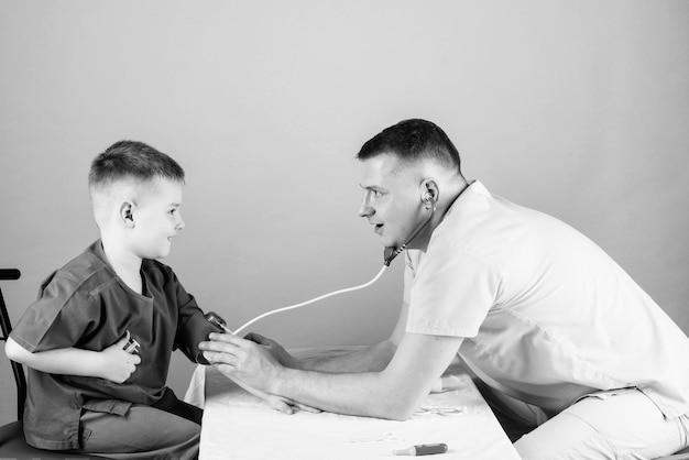 buen equipo niño feliz con padre con estetoscopio enfermera asistente de laboratorio médico de familia padre e hijo en uniforme médico medicina y salud niño pequeño con padre juego carrera futura