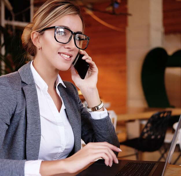 Buen negocio talkYoung mujer hermosa en gafas hablando por m