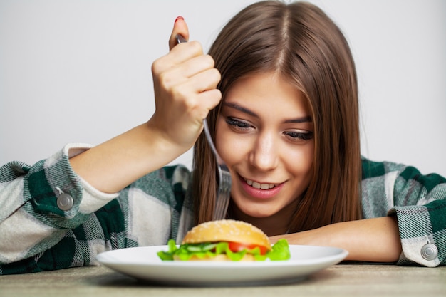 Buena chica quiere comer hamburguesa dañina