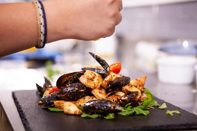 Buena cocina con mariscos en piedra negra en la cocina del restaurante. Comida deliciosa