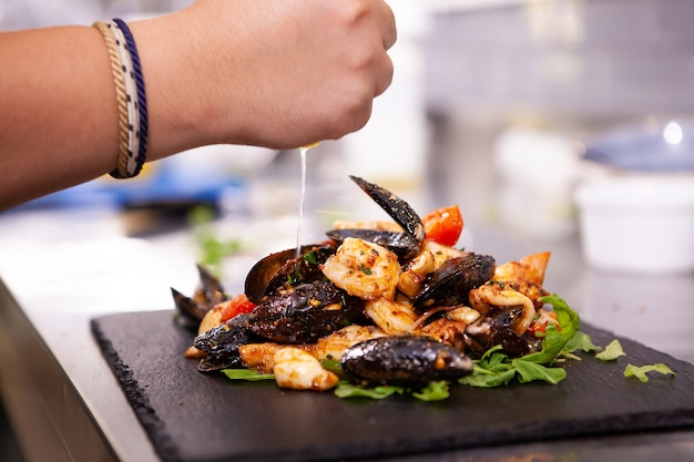 Buena cocina con mariscos en piedra negra en la cocina del restaurante. Comida deliciosa