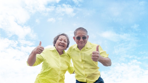 Buena confianza senior asiática saludable recomienda ir de vacaciones juntos en un cielo despejado con una camisa colorida