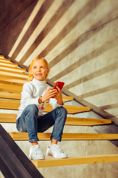 Foto buena idea. encantado de preescolar manteniendo una sonrisa en su rostro mientras está sumido en sus pensamientos