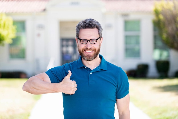 Buena salud ocular de un chico feliz con gafas con gesto de pulgar hacia arriba cuidado de los ojos