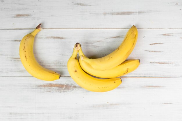 Bündel Bananen auf einem hölzernen Hintergrund Gewöhnliche Bananen mit Flecken