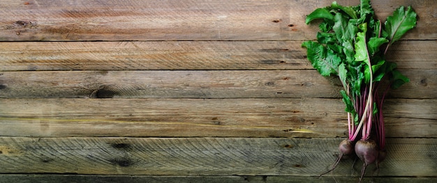 Bündel frische organische Rote-Bete-Wurzeln auf hölzernem Hintergrund. Konzept der Diät, rohe, vegetarische Mahlzeit.