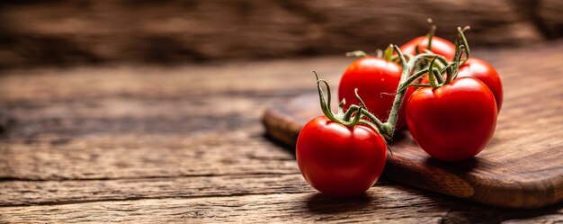 Bündel frische Tomaten auf einer rustikalen Holzoberfläche.