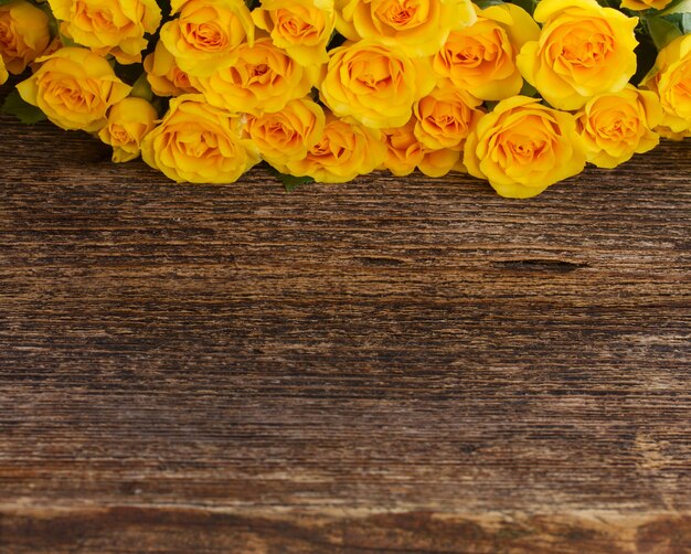 Bündel gelber Rosen mit Kopienraum auf Holz