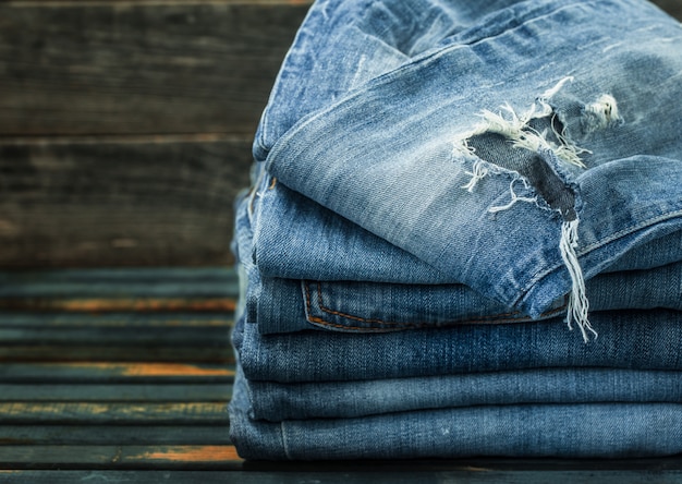 Bündel Jeans auf Holztisch, modische Kleidung