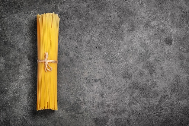 Bündel roher Spaghetti mit Seil auf Schwarz gebunden