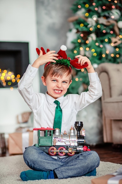 Buenos días, feliz, niño, regalo, tren de juguete, debajo, el, árbol de navidad, en, un, año nuevo, mañana