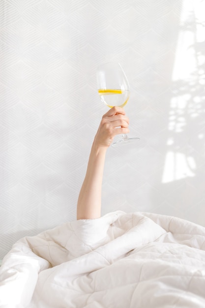 Buenos días vaso de agua con desayuno de limón en la cama