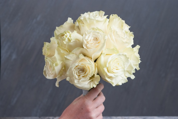 Buequet de boda con rosas blancas sobre fondo gris. De cerca