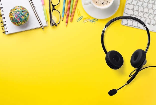 Büro gelber Hintergrund mit Vorräten und Headset