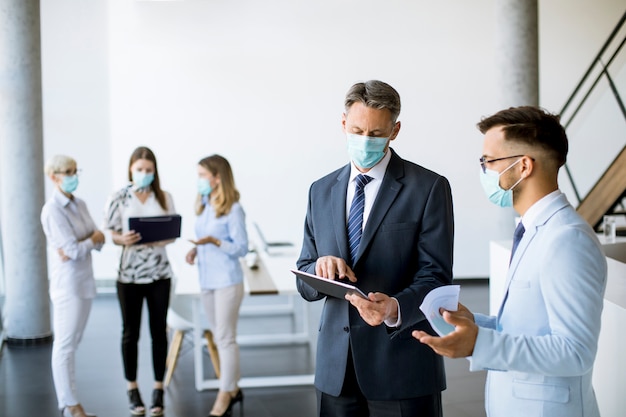 Büroangestellte treffen sich im Büro mit Gesichtsmasken, um sich vor Coronaviren zu schützen