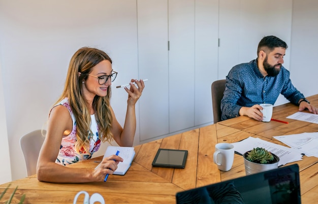 Büroangestellter, der Handy mit Lautsprecher spricht