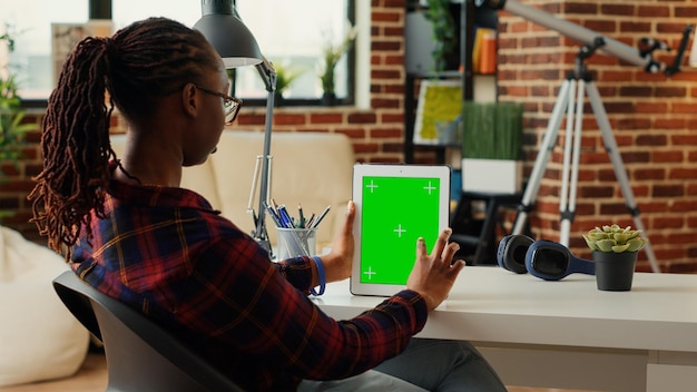 Büroangestellter, der modernes Gadget mit Greenscreen-Vorlage vertikal hält und leere Vorlage mit isoliertem Hintergrund und Mockup analysiert. Verwenden des Copyspace-Chroma-Key-Bildschirms.