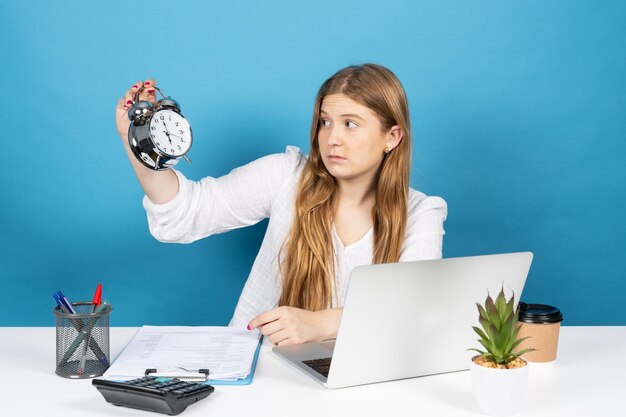 Büroangestellter, der Wecker hält