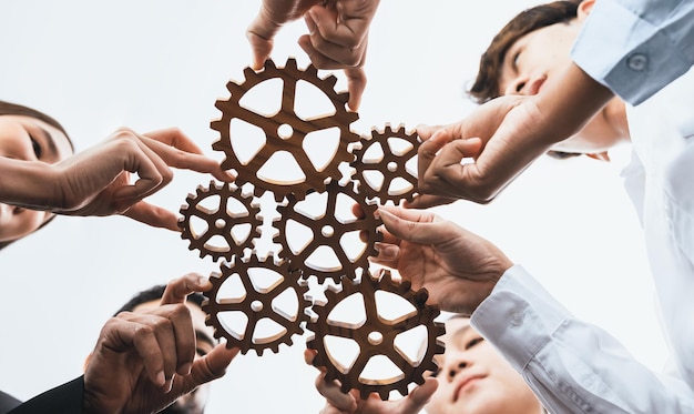 Foto büroangestellter hält das zahnrad als einheit und teamarbeit in der arbeitsumgebung