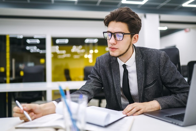 Büroangestellter mit Brille liest Dokumente in office.business manager arbeitet mit neuem Startup-Projekt