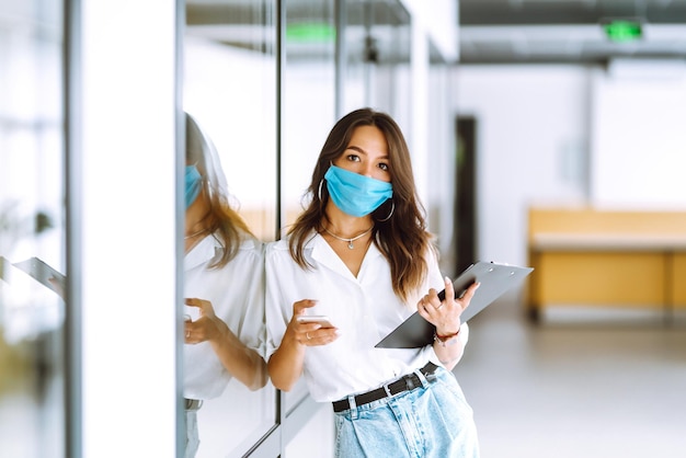 Büroangestellter mit Gesichtsmaske, der im Büro arbeitet Das Konzept zur Verhinderung der Ausbreitung der Epidemie