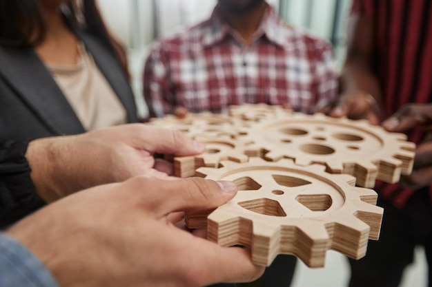 Büroangestellter mit Zahnrad als Einheit und Teamarbeit im Unternehmensarbeitsplatzkonzept